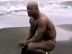 Asian bodybuilder barely covered at the beach